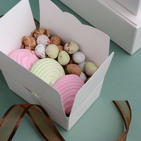 Small white ballotin box, open to reveal coloured meringues and mini Easter eggs