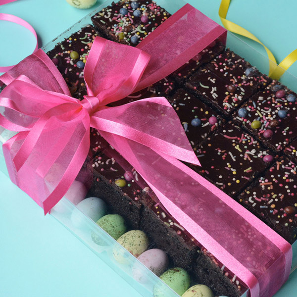 Clear box filled with brownies and pastel Easter eggs. Tied with a hot pink ribbon