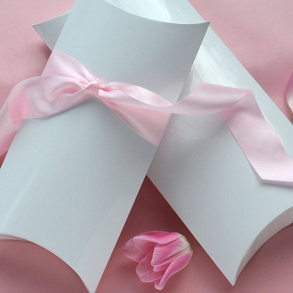 2 white gloss pillow boxes with a pale pink satin ribbon
